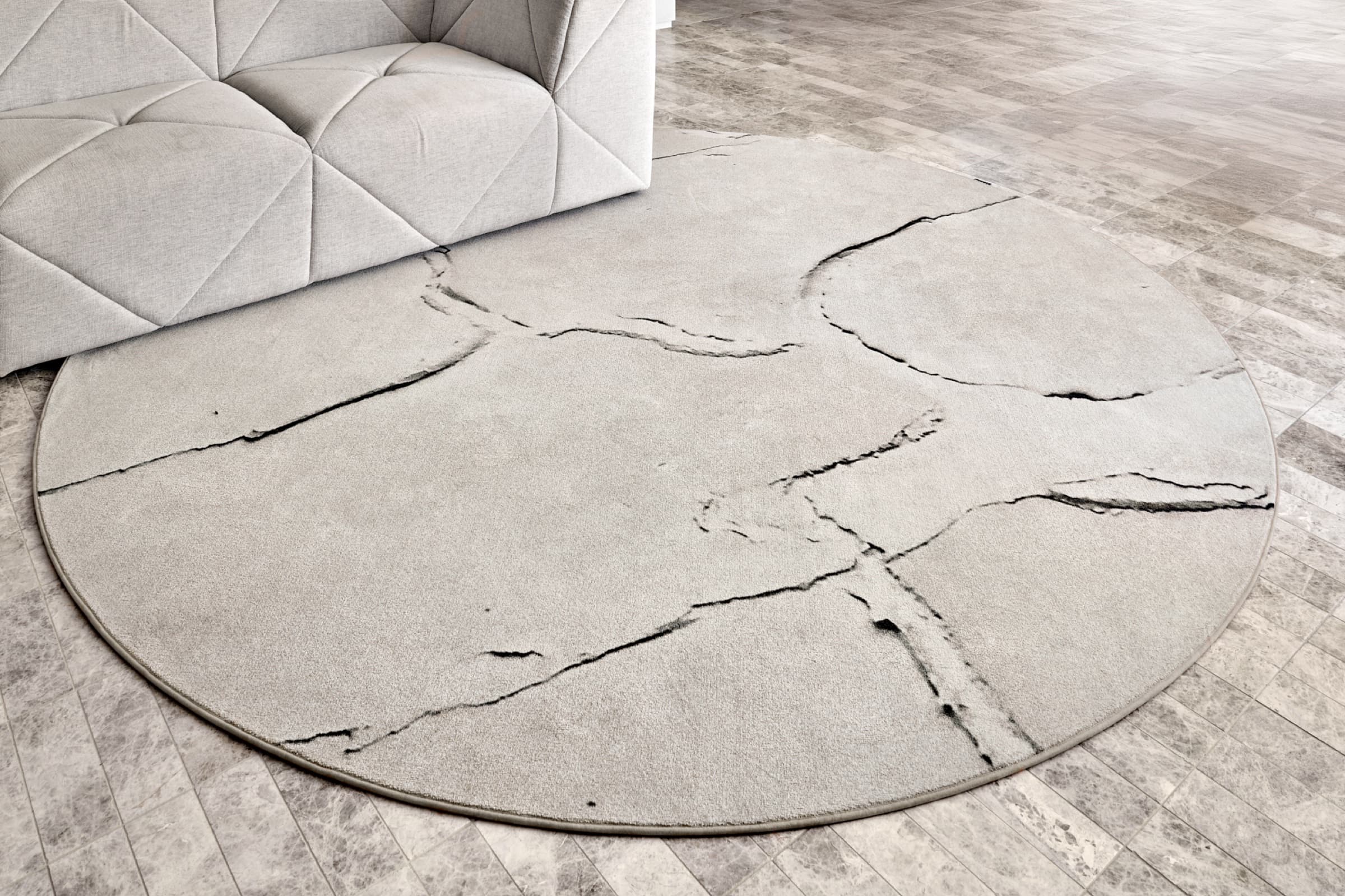 Marble-veined rug detail with sculptural sofa